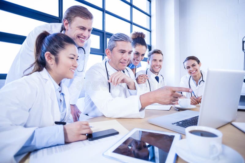 Medisch team die laptop onderzoeken en een bespreking hebben stock fotografie Medisch team die laptop onderzoeken en een bespreking hebben stock fotografie
