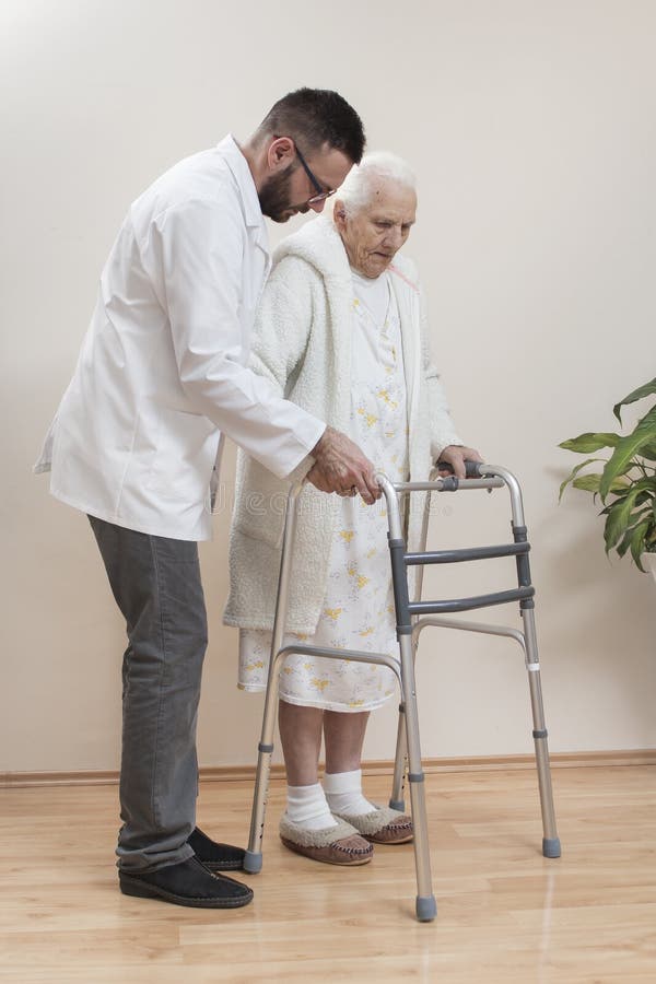 Medische rehabilitatiebalkons De oma leert om met behulp van een leurder en bijgewoond door een verpleegster te lopen royalty-vrije stock afbeeldingen Medische rehabilitatiebalkons De oma leert om met behulp van een leurder en bijgewoond door een verpleegster te lopen royalty-vrije stock afbeeldingen