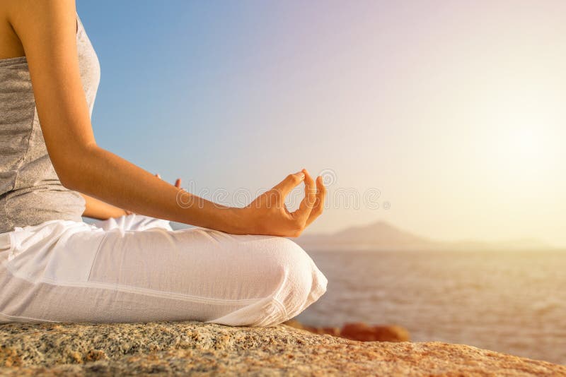 Meditationsyogahaltung der jungen Frau auf tropischem Strand mit Sonnenlicht stockbild Meditationsyogahaltung der jungen Frau auf tropischem Strand mit Sonnenlicht stockbild