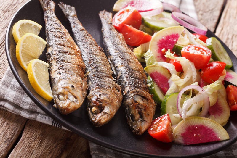 Mediterranean cuisine: grilled sardines with fresh vegetable sal