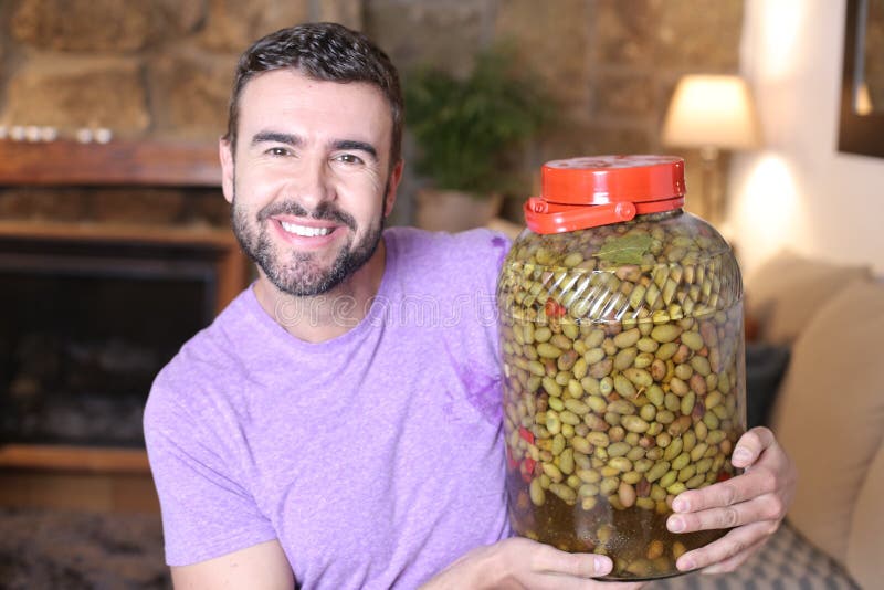 Mediterranean Man Holding Large Bottle of Delicious Olives Stock Photo