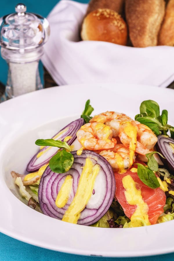 Mediterranean salad. grilled prawns, red onion rings, lemon peel, ginger root and vegetables dressed with olive oil stock photos