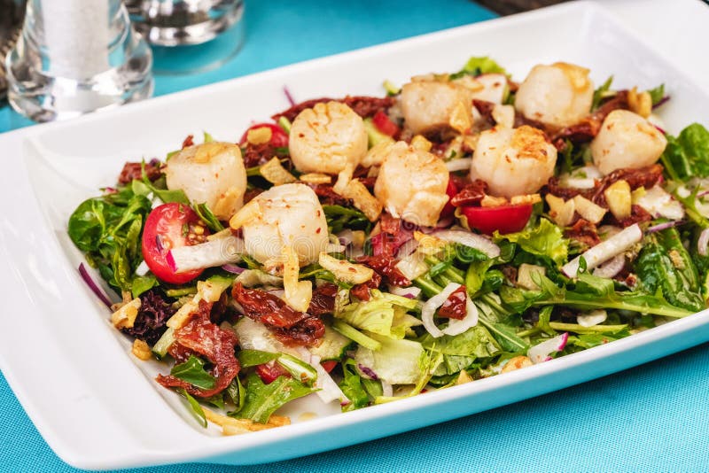 Mediterranean salad of radish, arugula, fried shrimp, chili peppers, cucumbers with olive oil royalty free stock photos