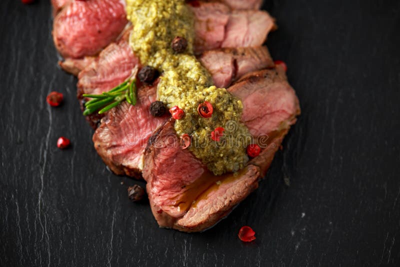 Medium Rare Venison Steak with Green Pesto Sauce and Pepper Stock Image