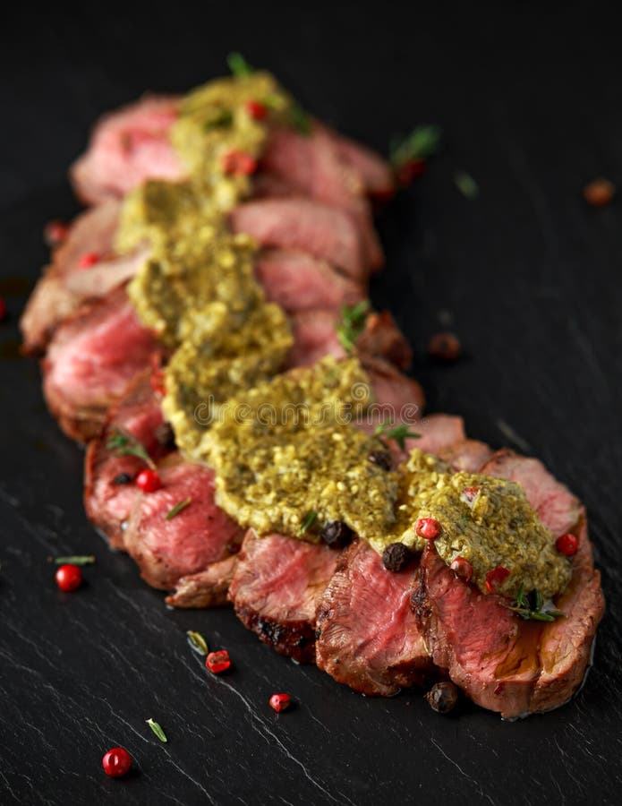 Medium Rare Venison Steak with Green Pesto Sauce and Pepper Stock Image