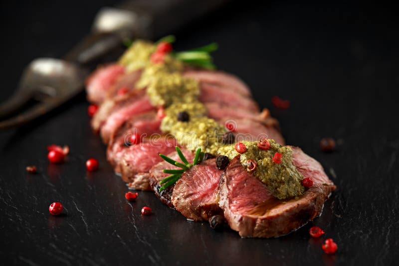 Medium Rare Venison Steak with Green Pesto Sauce and Pepper Stock Image
