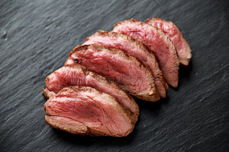 Medium Rare Venison Steak on Rustic Dark Stone Board Stock Image