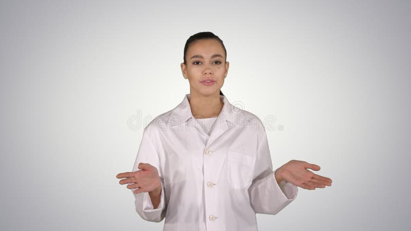 Attractive doctor pointing to the side presenting product on gradient background. stock image Attractive doctor pointing to the side presenting product on gradient background. stock image