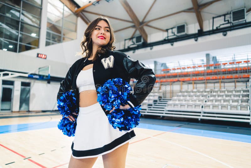 Premium Photo  Cheerleader girls team standing in lines with pompons in  front of them on a court