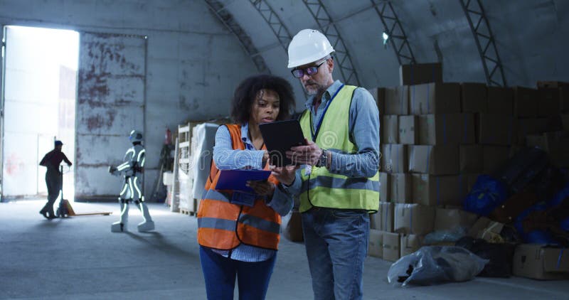 Engineers talking while robot working in the background royalty free stock photos Engineers talking while robot working in the background royalty free stock photos