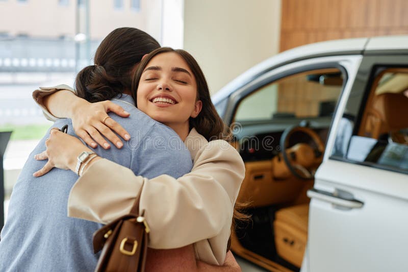 Smiling Woman Hugging Husband after Buying Car at Dealership Center stock images