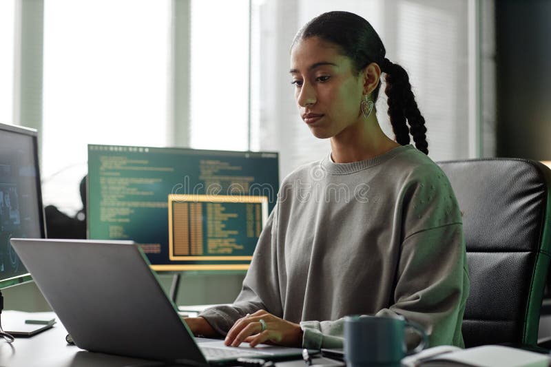 Middle Eastern Female Programmer Using Laptop Sitting at Workstation in Office stock photos