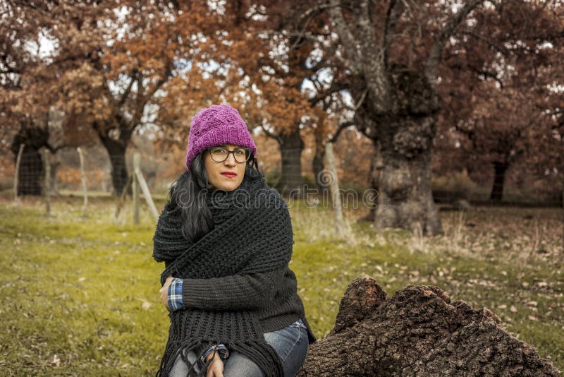 Medium Shot Portrait Serious Woman with Glasses Sit on a Tree Tr Stock