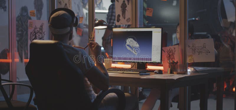 Man modeling dinosaur skull on computer. Medium shot of a VR headset wearing young men modeling dinosaur skull on computer stock photo Man modeling dinosaur skull on computer. Medium shot of a VR headset wearing young men modeling dinosaur skull on computer stock photo