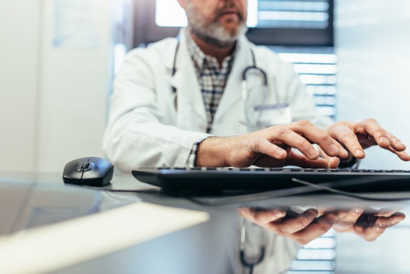Medizinischer Fachmann, der Computertastatur in der Klinik verwendet stockfotografie Medizinischer Fachmann, der Computertastatur in der Klinik verwendet stockfotografie