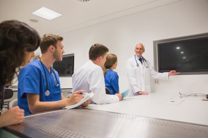 Medizinischer Professor, der junge Studenten unterrichtet lizenzfreie stockfotos Medizinischer Professor, der junge Studenten unterrichtet lizenzfreie stockfotos