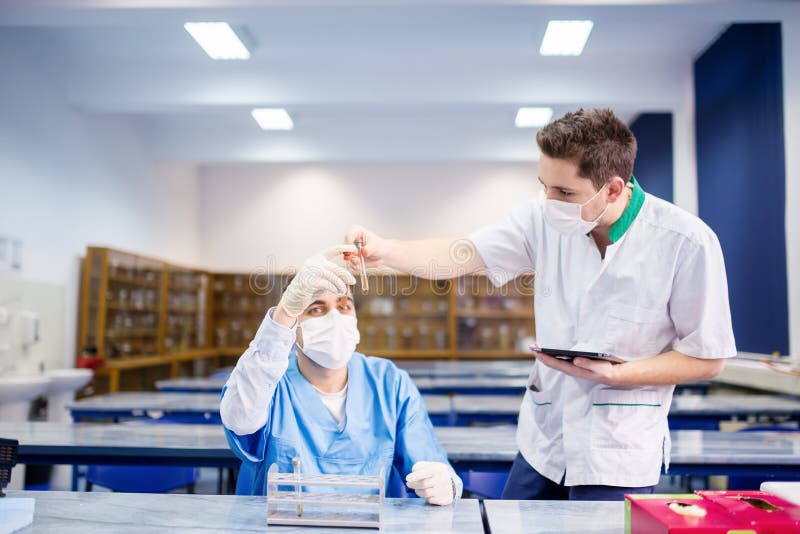Medizinstudenten, die Experimente durchführen und Proben vergleichen lizenzfreies stockfoto Medizinstudenten, die Experimente durchführen und Proben vergleichen lizenzfreies stockfoto