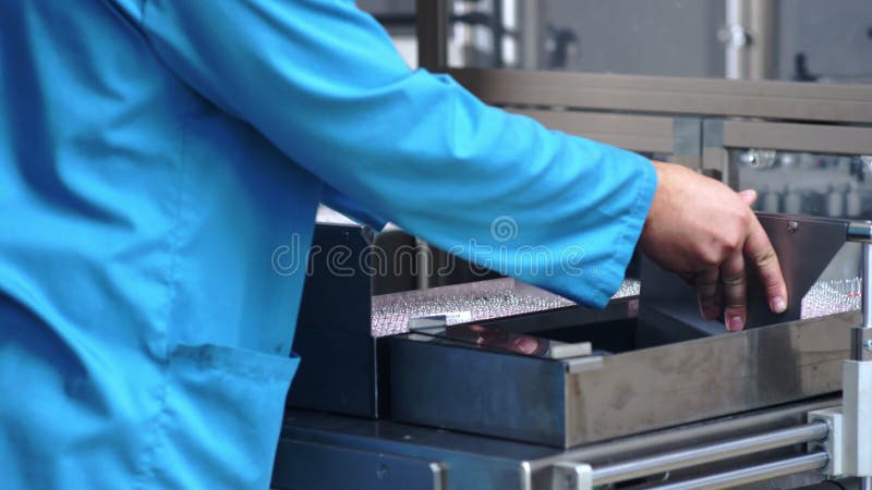 Medyczna buteleczki linia produkcyjna Pracownik fabryczny pakuje medyczne ampułki