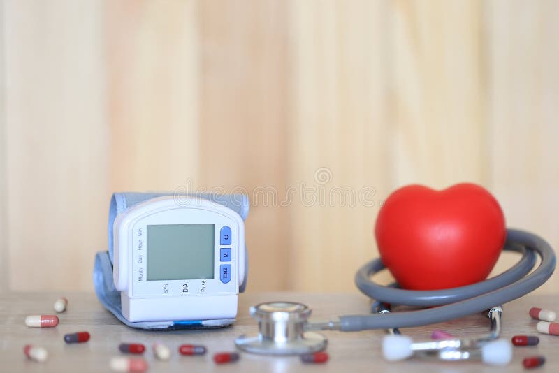 Medyczny tonometer dla pomiarowego ciśnienia krwi z stetoskopem i czerwieni serce na tle, wydatkach na leczenie i zdrowie wooder, zdjęcia stock Medyczny tonometer dla pomiarowego ciśnienia krwi z stetoskopem i czerwieni serce na tle, wydatkach na leczenie i zdrowie wooder, zdjęcia stock