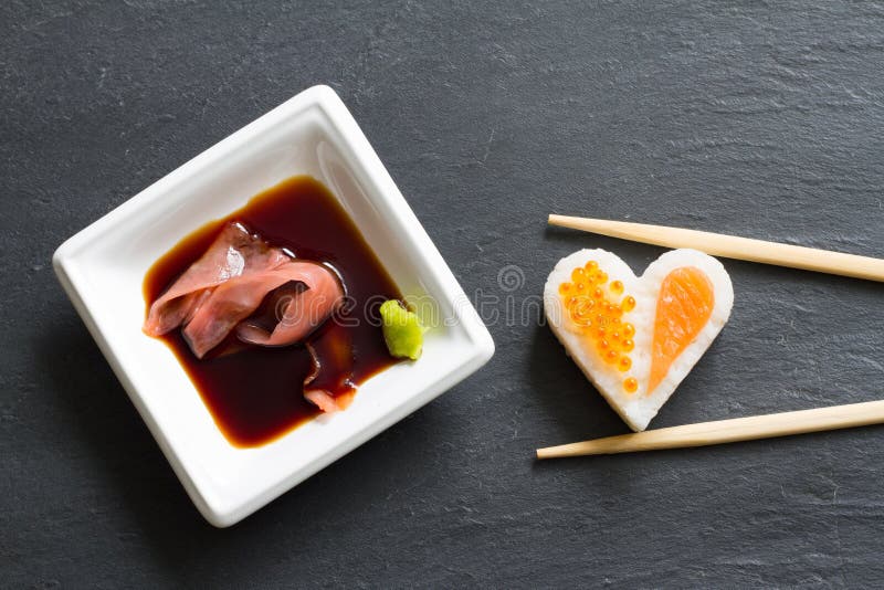 Meeresfrüchte-Herzkonzept der Sushi abstraktes auf schwarzem Marmormenühintergrund stockfotografie