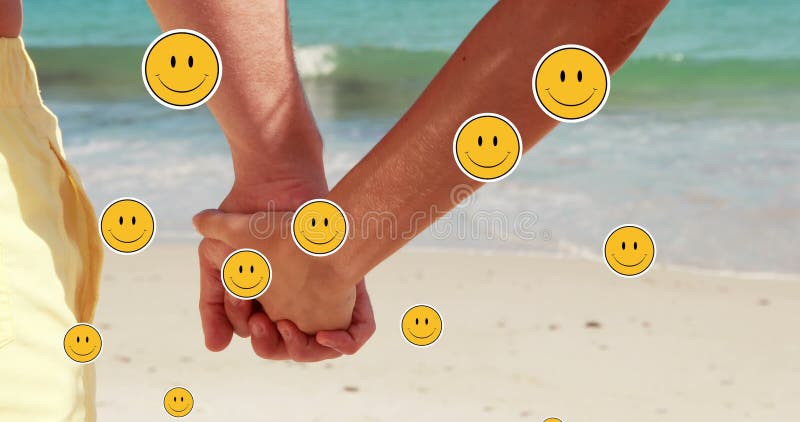 Meervoudig glimlachend gelaat emoji zwevend tegen het midden van een paar dat handen houdt op het strand