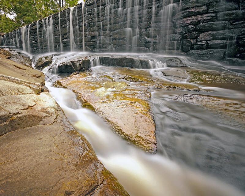 Water rushing down a granite spillway, off a rock dam that dates to at least 1755. This 168 second exposure emphasizes the power of the water running through the crevice and shows teh contrast of the rushing water and stately rocks. Water rushing down a granite spillway, off a rock dam that dates to at least 1755. This 168 second exposure emphasizes the power of the water running through the crevice and shows teh contrast of the rushing water and stately rocks.