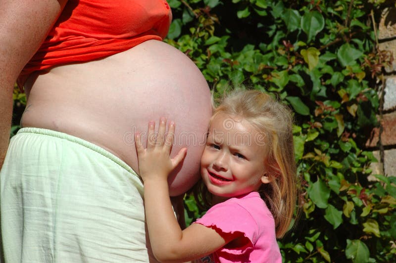 Hermoso caucásico largo tiempo cabello publicidad entusiasmado expresión posesión el gran barriga de su madre cual es un esperar un nino chico.