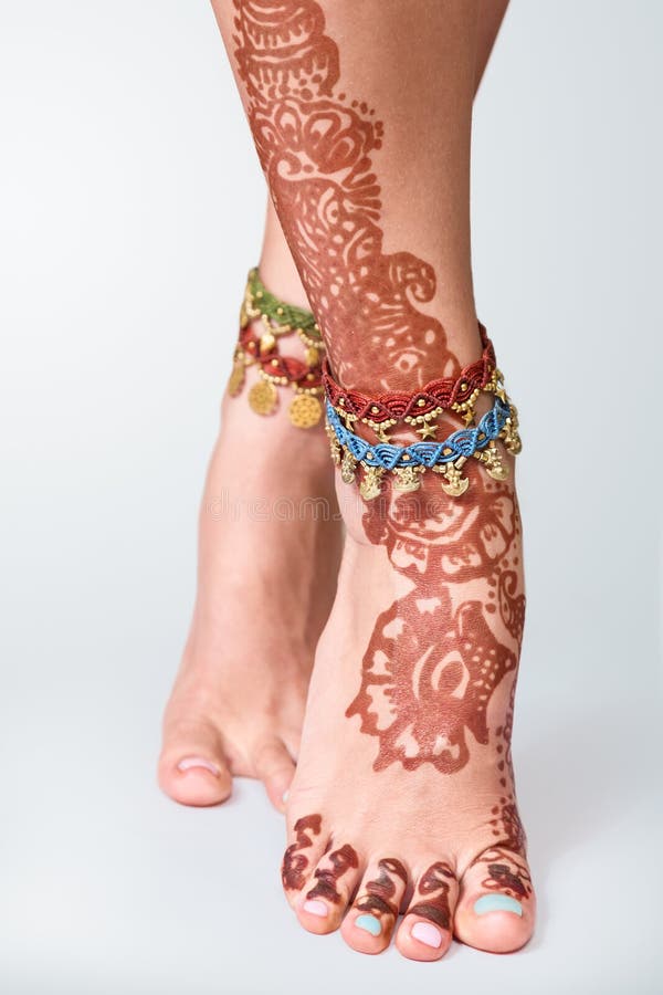 Legs decorated with indian mehandi painted henna and braceletes close up. Legs decorated with indian mehandi painted henna and braceletes close up