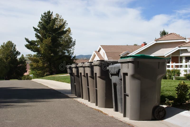 Garbage bins line up on a residential street. Garbage bins line up on a residential street.