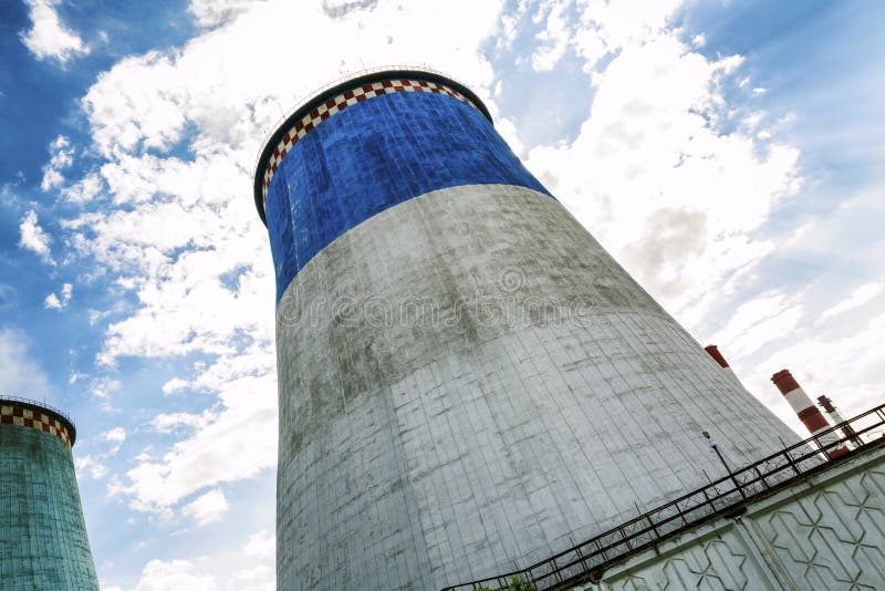 Mehrfarbige Kühltürme auf einem Hintergrund des hellen blauen Himmels stockbild Mehrfarbige Kühltürme auf einem Hintergrund des hellen blauen Himmels stockbild