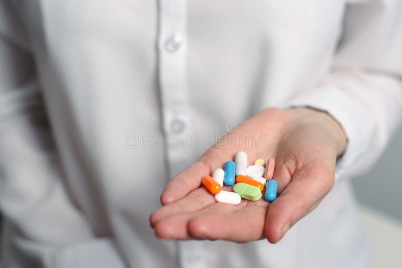 Mehrfarbige Pillen in einer weißen weiblichen Hand, Ausdehnungen vorwärts lizenzfreie stockfotografie Mehrfarbige Pillen in einer weißen weiblichen Hand, Ausdehnungen vorwärts lizenzfreie stockfotografie