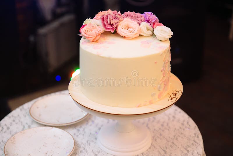 Mehrstufige Hochzeitstorte verziert mit Blumenständen auf einer Tabelle Konzept des Essens, der Bonbons und der Nachtische an ein stockfotografie Mehrstufige Hochzeitstorte verziert mit Blumenständen auf einer Tabelle Konzept des Essens, der Bonbons und der Nachtische an ein stockfotografie
