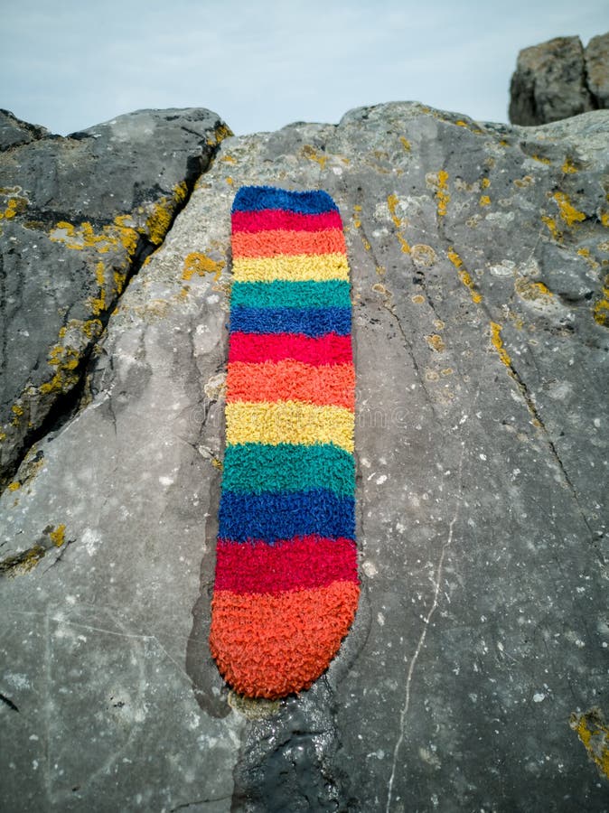Meia do arco-íris perdida na praia