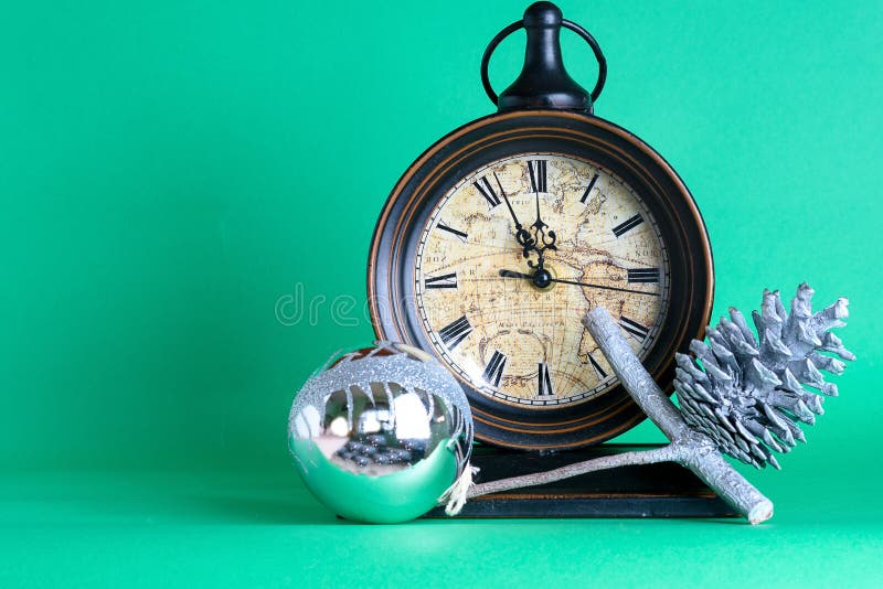 Meia-noite, quinquilharia e cone do pulso de disparo de ano novo no ramo de árvore do abeto do pinho Fundo verde Papai Noel em um fotografia de stock royalty free Meia-noite, quinquilharia e cone do pulso de disparo de ano novo no ramo de árvore do abeto do pinho Fundo verde Papai Noel em um fotografia de stock royalty free