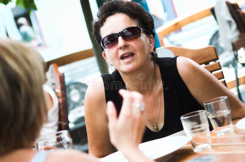 Best friends talking in an outdoor cafe. Best friends talking in an outdoor cafe