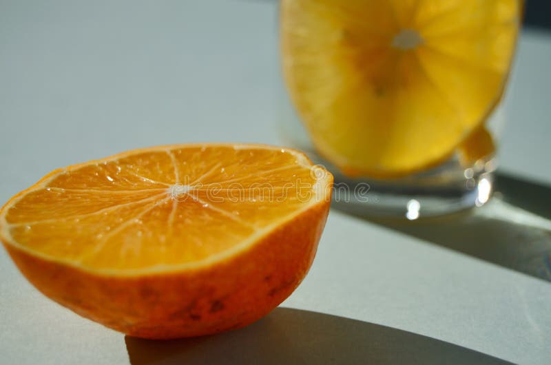 Meio limão sobre o fundo de um copo de limonada imagens de stock royalty free