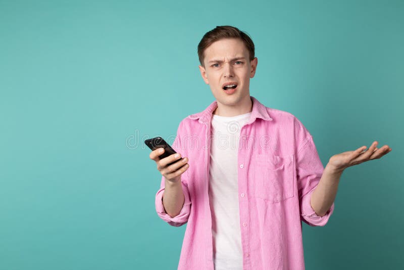 Meio retrato do comprimento de um homem infeliz confuso na camisa cor-de-rosa imagem de stock royalty free Meio retrato do comprimento de um homem infeliz confuso na camisa cor-de-rosa imagem de stock royalty free
