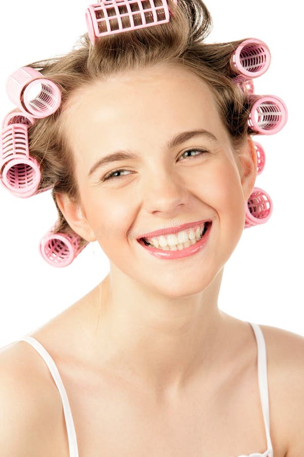 Laughing teenage girl wearing hair curlers isolated on white background. Laughing teenage girl wearing hair curlers isolated on white background