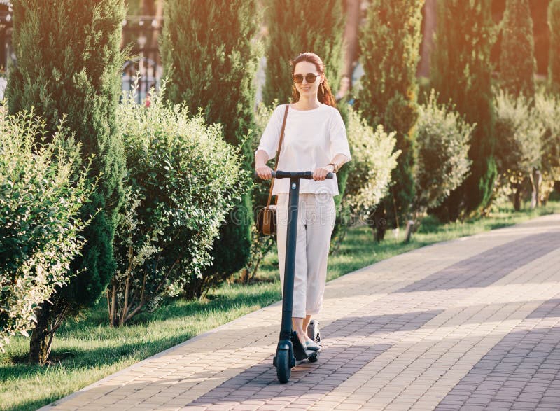 Meisje dat op elektrische autoped in de zomerpark berijdt royalty-vrije stock foto's Meisje dat op elektrische autoped in de zomerpark berijdt royalty-vrije stock foto's