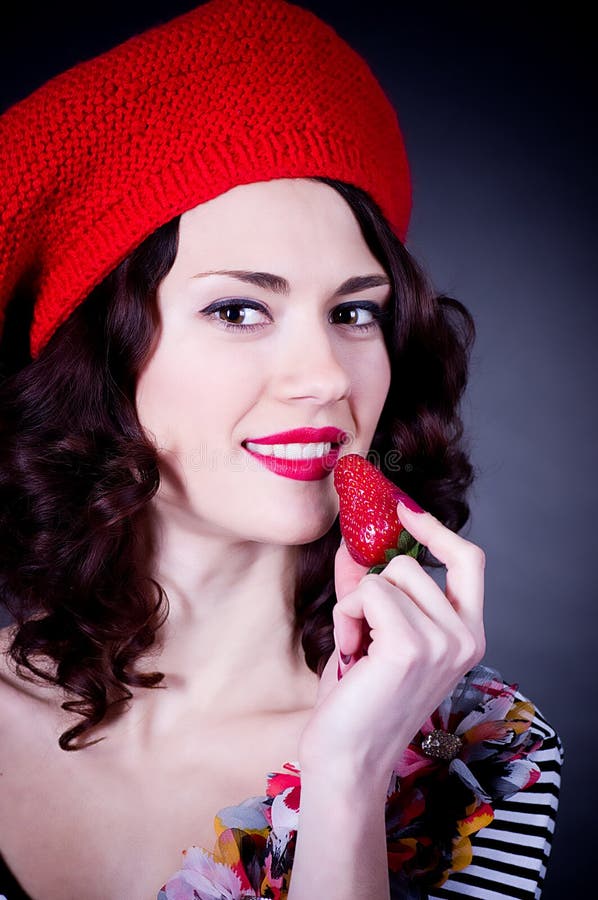 Meisje dat in rode baret aardbei eet. stock fotografie Meisje dat in rode baret aardbei eet. stock fotografie