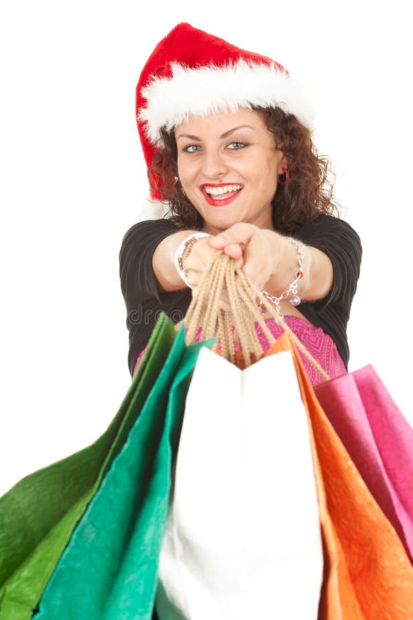 Meisje in de hoed van de Kerstman dragende het winkelen zakken stock fotografie Meisje in de hoed van de Kerstman dragende het winkelen zakken stock fotografie