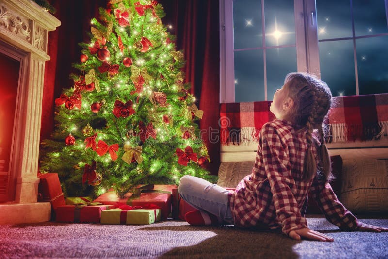 Meisje die decoratie bekijken de Kerstboom stock fotografie Meisje die decoratie bekijken de Kerstboom stock fotografie