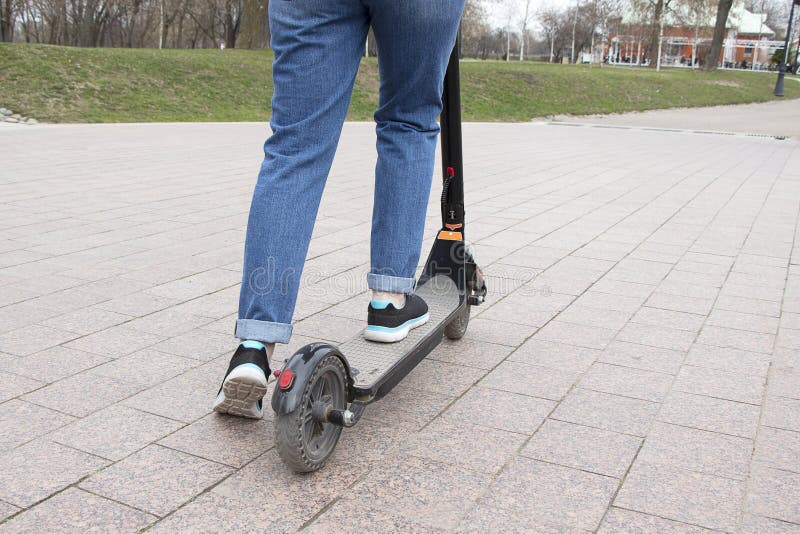 Meisje die een elektrische autoped in de parkweg berijden Technologisch milieuvriendelijk vervoer Moderne actieve levensstijl royalty-vrije stock fotografie Meisje die een elektrische autoped in de parkweg berijden Technologisch milieuvriendelijk vervoer Moderne actieve levensstijl royalty-vrije stock fotografie