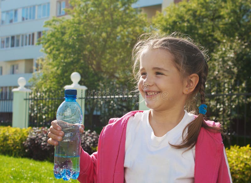 Meisje die een plastic fles met water houden royalty-vrije stock foto's Meisje die een plastic fles met water houden royalty-vrije stock foto's