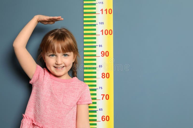 Meisje die haar hoogte meten stock foto Meisje die haar hoogte meten stock foto