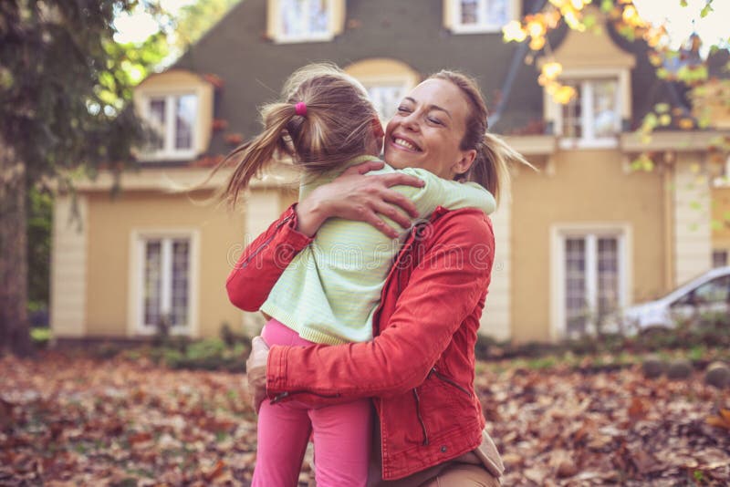 Een klein meisje omhelst haar Moeder, deelt liefde royalty-vrije stock foto