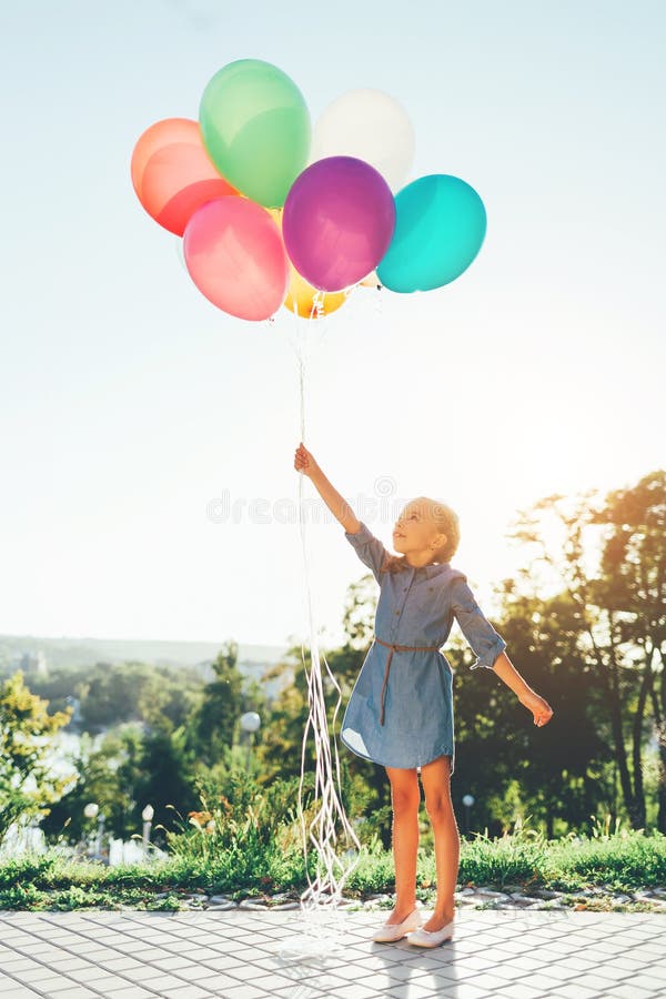 Meisje die kleurrijke ballons houden zich uitrekt aan de hemel en dreamin stock foto's Meisje die kleurrijke ballons houden zich uitrekt aan de hemel en dreamin stock foto's