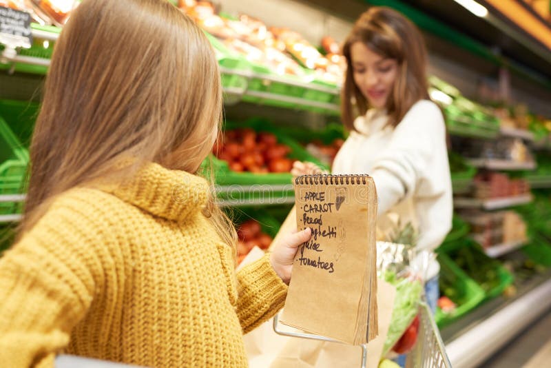 Meisje die Kruidenierswinkel het Winkelen bevorderen stock foto Meisje die Kruidenierswinkel het Winkelen bevorderen stock foto