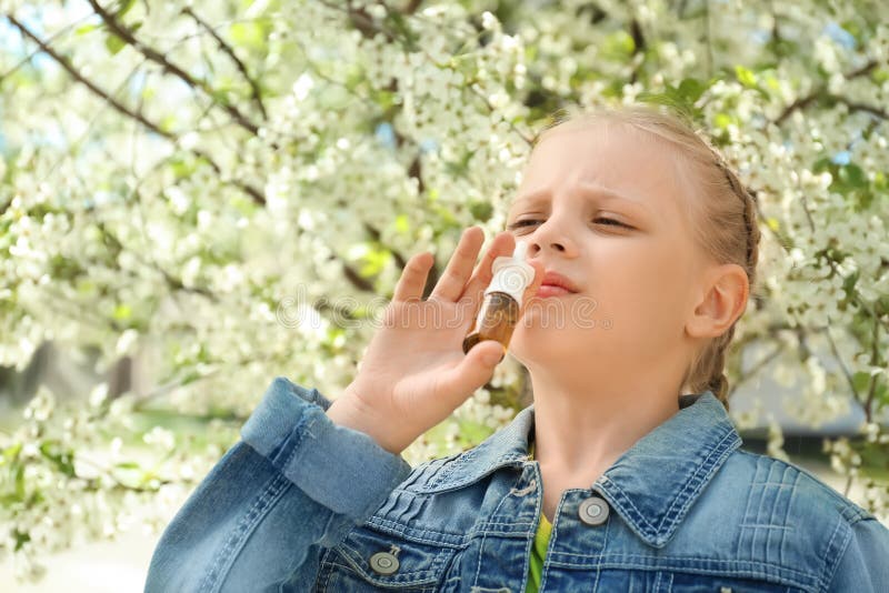 Meisje die neusdalingen dichtbij bloeiende boom gebruiken Allergieconcept