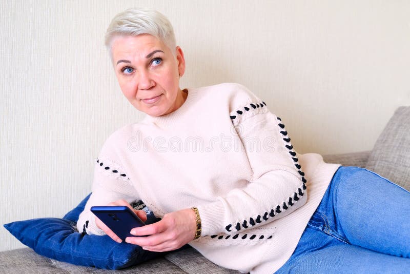 Meisje die SMS in smartphone lezen De emotie van blije verrassing Het korte kapsel van vrouwen Modieus modieus profiel met stock foto Meisje die SMS in smartphone lezen De emotie van blije verrassing Het korte kapsel van vrouwen Modieus modieus profiel met stock foto